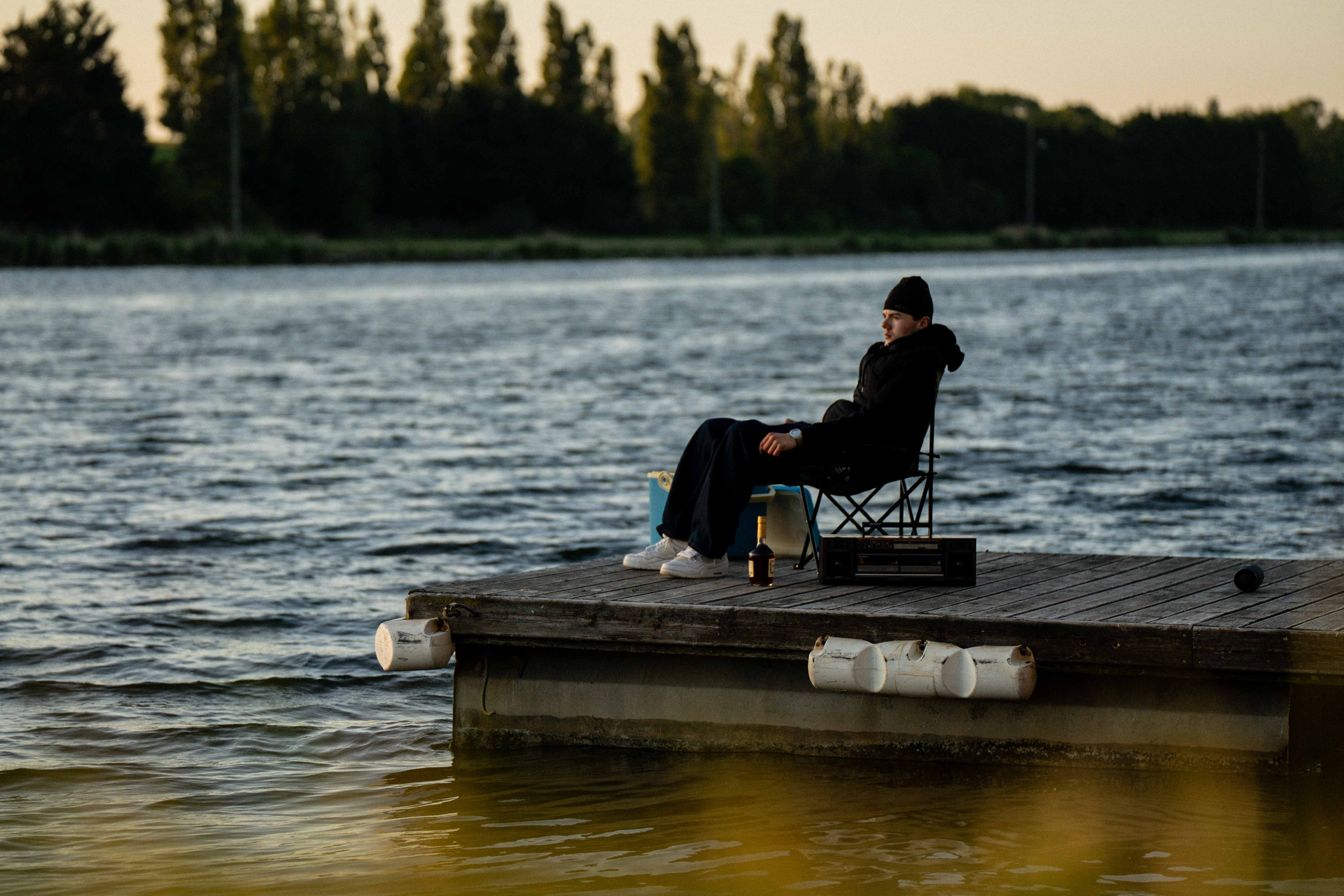 Rocka assis sur une chaise en bois au bord de l’eau