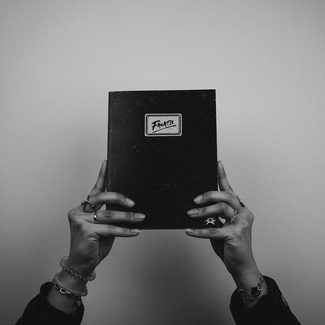 Personne tenant un livre noir des deux mains