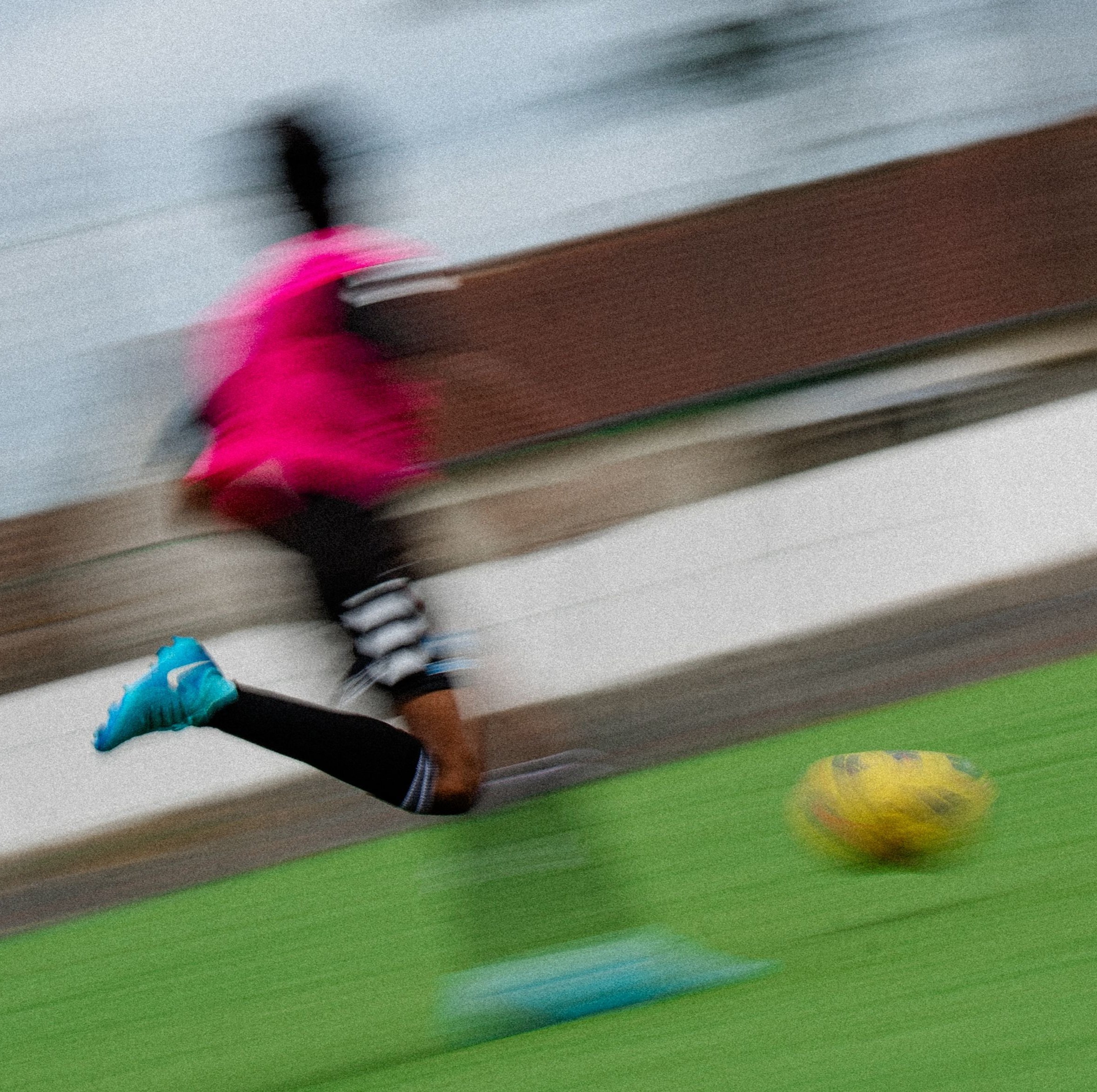 Jeune joueur de foot courant vers le ballon