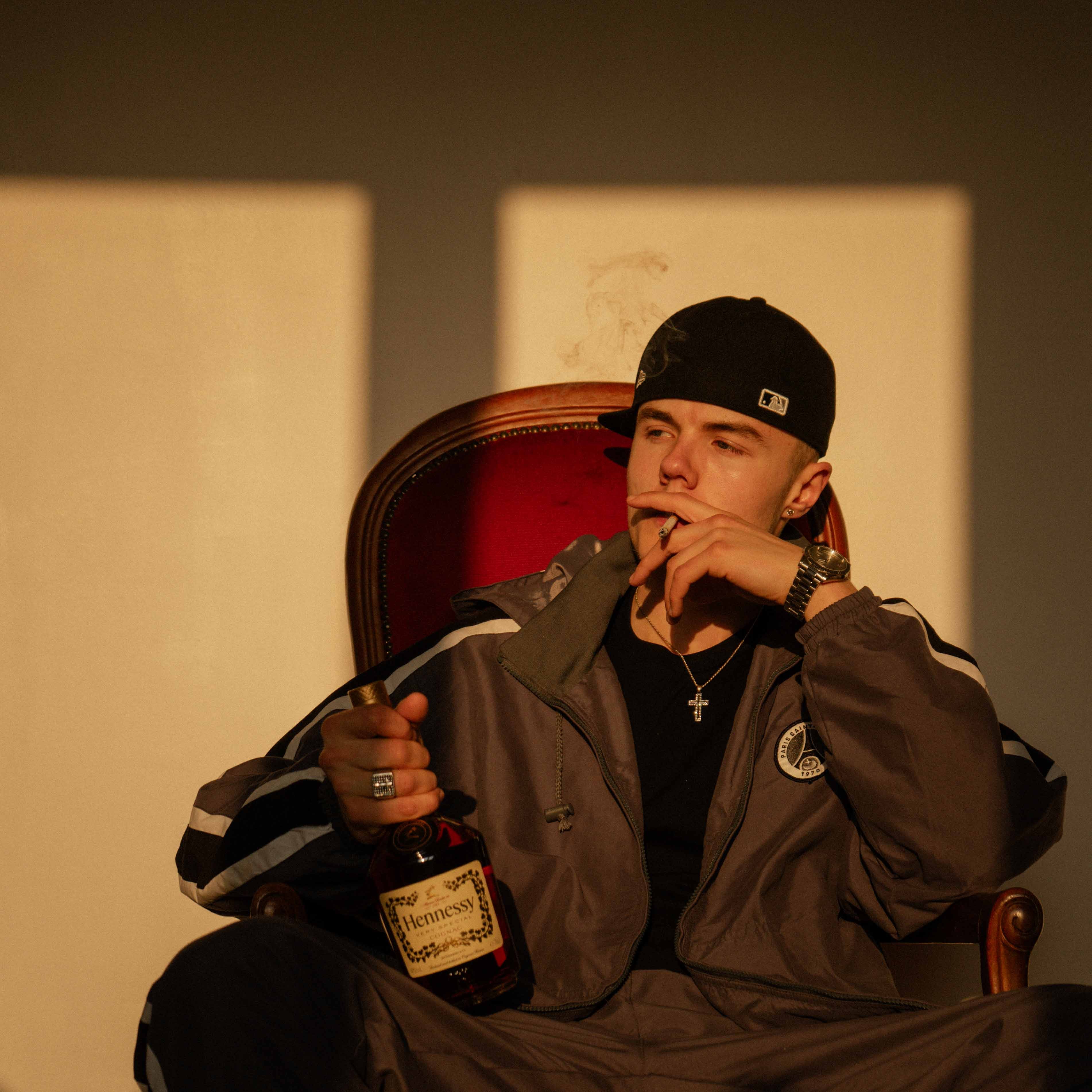 Rocka posant assis avec une bouteille de whisky