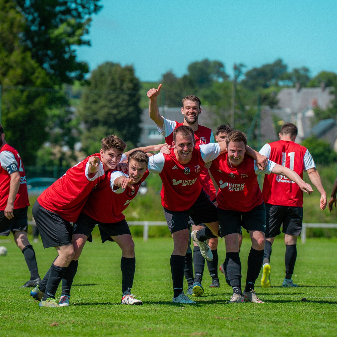Équipe de football en maillot rouge regroupée après un but