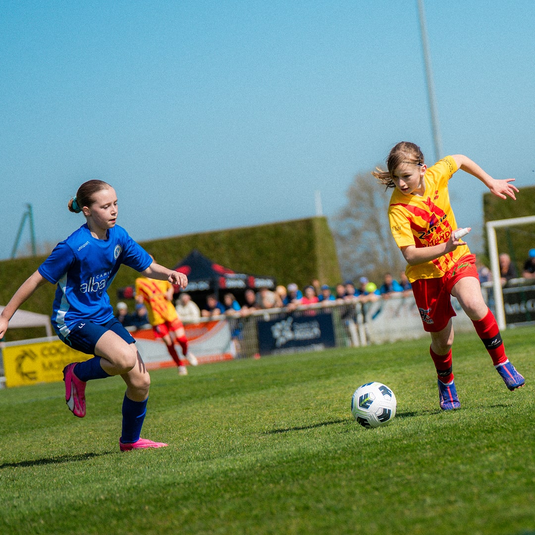 Match féminin avec joueuse en bleu et adversaire en jaune