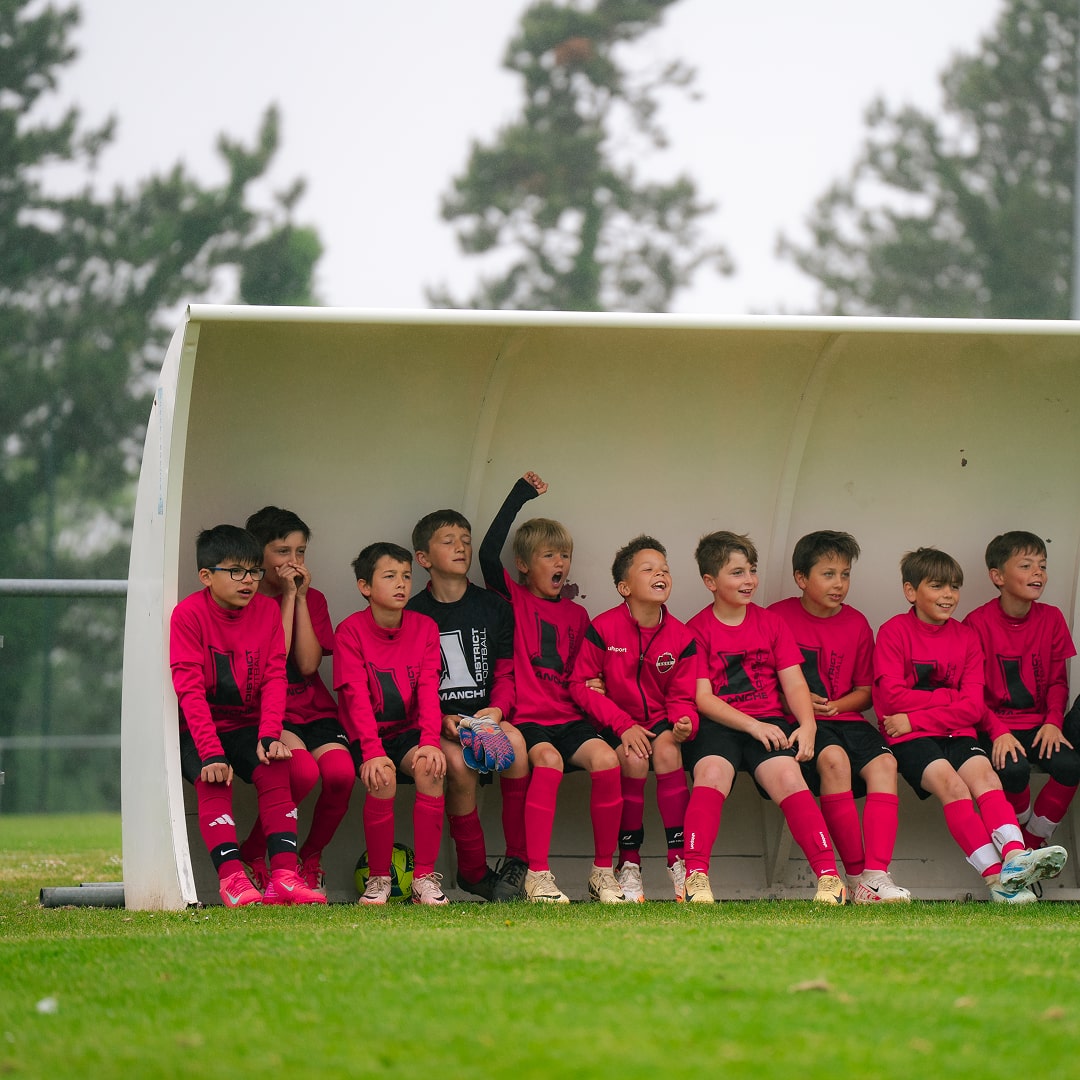 Équipe de jeunes joueuses en maillot rose sur le banc