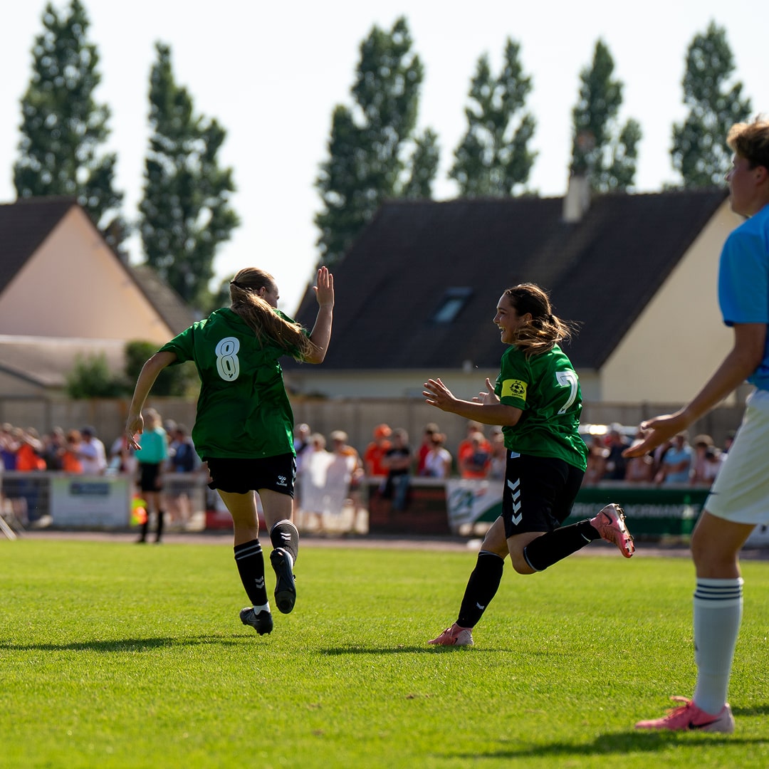 Match de football avec joueur en vert poursuivant le ballon
