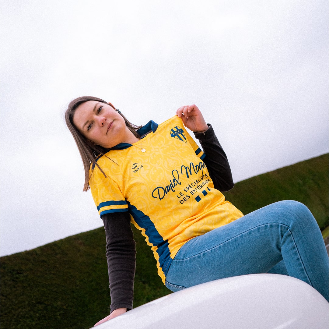 Personne assise sur une voiture portant un maillot jaune
